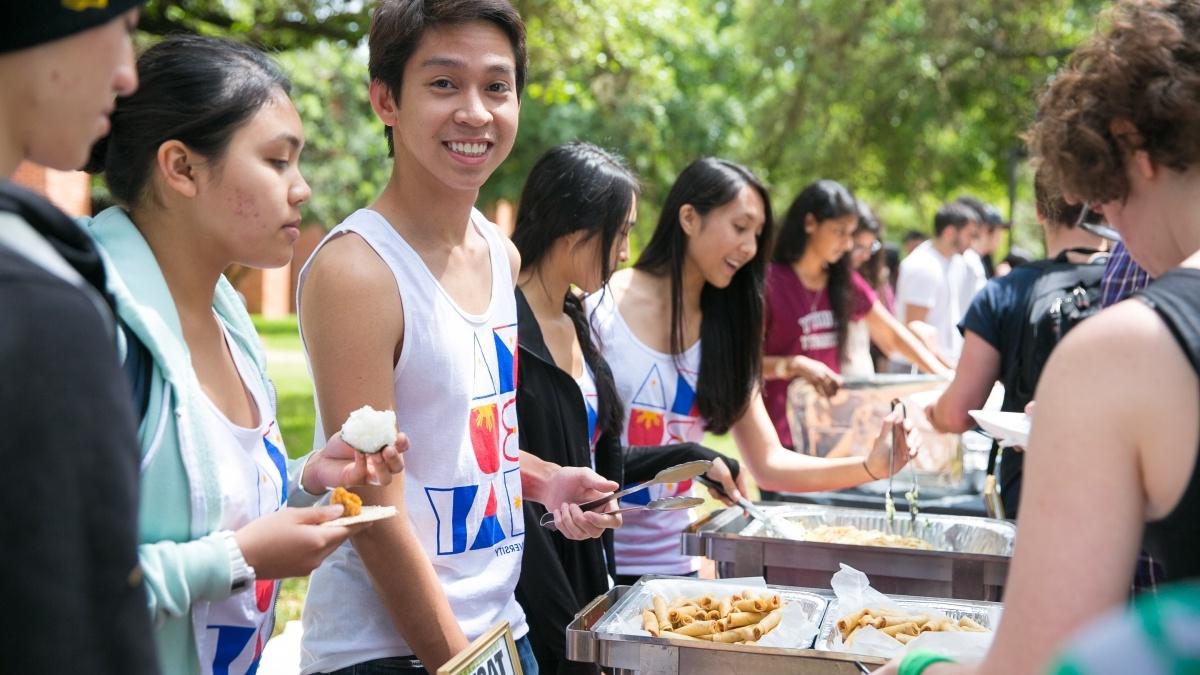 a male student serves food in line at 品味多样性